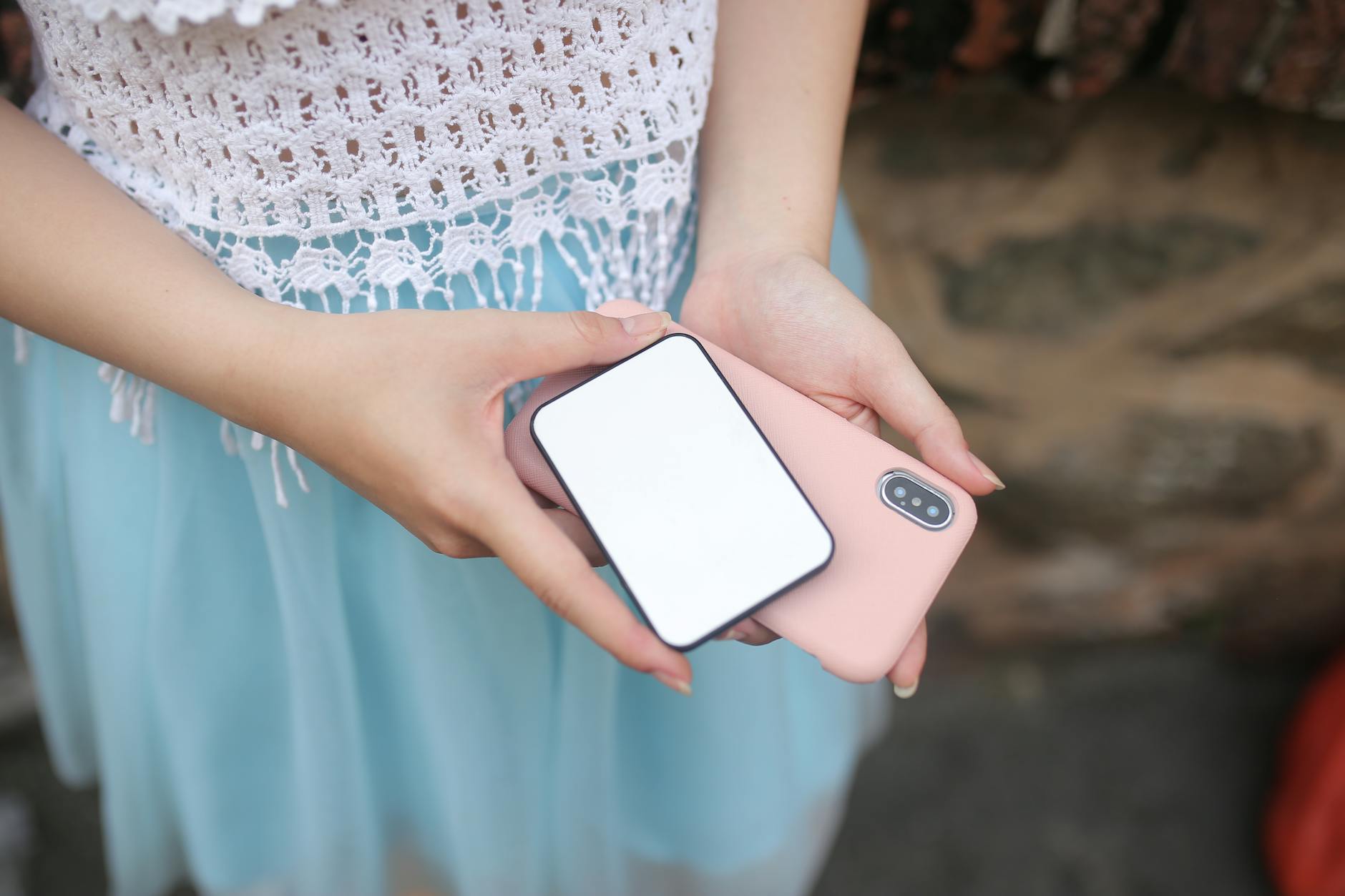 woman in white lace dress holding white smartphone